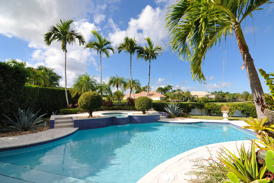 Palm-lined pool terrace overlooking a South Florida lake